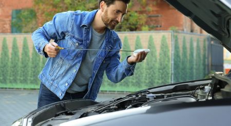 Man,Checking,Motor,Oil,Level,With,Dipstick,Outdoors